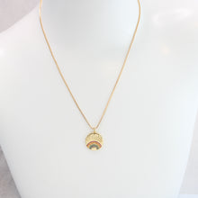 An 18K gold plated rainbow necklace with multicolored cubic zirconia rhinestones, on a box chain on a mannequin. 