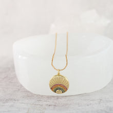 Close up view of a 18K gold plated rainbow burst necklace with multicolored cubic zirconia rhinestones, on a box chain.