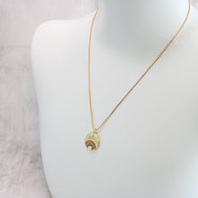 An 18K gold plated rainbow burst necklace with multicolored cubic zirconia rhinestones, on a mannequin. 