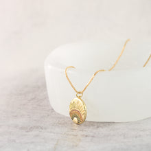 18K gold plated rainbow disc pendant necklace in a jewelry tray. 