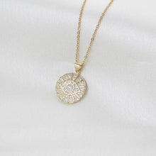 Gold stainless steel Evil Eye rhinestone pendant necklace with sparkling crystal accents on soft white background. 