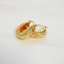 A pair of textured gold hoop earrings with a woven or basketweave-like pattern, displayed on a clean white surface.