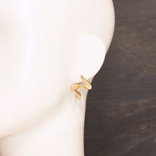 Wavy Ribbon Gold Drop Earrings Stainless Steel on mannequin against a dark background. 