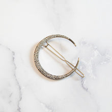 Crescent moon rhinestone hair clip on white marble background