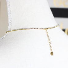 Back view of a gold-tone stainless steel necklace with a heart-shaped rhinestone pendant on a mannequin. 