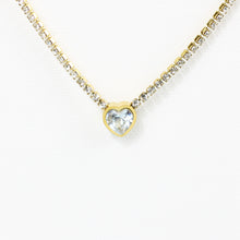 A gold-tone stainless steel necklace with a rhinestone chain and rhinestone heart-shaped pendant.