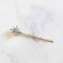 Mini rhinestone star hair pin on marble background