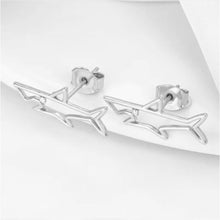 Pair of shark stud earrings on a white background. 