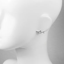 Silver shark stud earring on mannequin ear. 