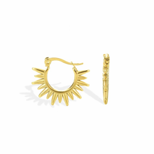 Gold hoop earrings with sunburst design on a white background