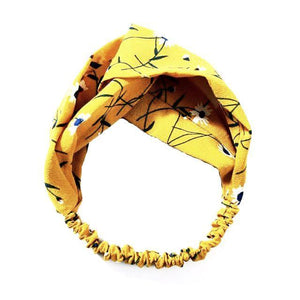 Stylish twist loop nylon headband with elastic for comfort fit. Colors: Yellow with navy blue and white floral pattern.