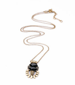 Unique geometric gold tone pendant with black gemstones on a long gold tone chain. Necklace measures 32' long with 2 1/2" extension. Pendant measures 1 3/4" long by 1" wide.