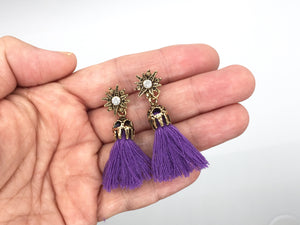 Antique gold color star stud with rhinestone and purple tassel. Remove the tassel to wear the star studs alone. Earrings measure 1 3/4" long when worn with tassel.