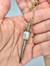 Glam spike necklace with clear rhinestones and an antique gold color chain. Necklace measures 14" long with 3" extension. Pendant measures 2 3/8" long.