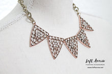 Two tone triangle statement necklace. This necklace measures 18" and fits like a choker. Triangles are a copper color and chain is in a gold tone color with a vintage finish.