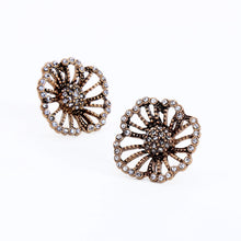 Vintage style rhinestone flower stud earrings on white background. 