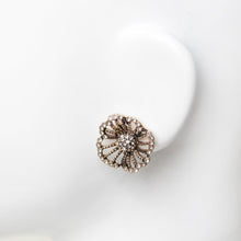 Vintage style rhinestone flower stud earring close-up on mannequin ear.