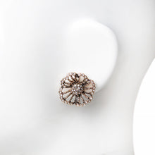 Vintage style rhinestone flower stud earring close-up on mannequin ear.